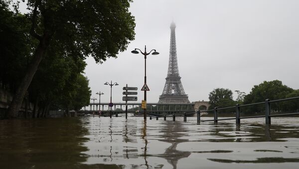 A picture taken on June 2, 2016 shows the river Seine bursting its banks next to the Eiffel Tower in Paris. Officials were putting up emergency flood barriers on June 2 along the swollen river Seine after days of torrential rain -- including near the Louvre, home to priceless works of art. - Sputnik Afrique