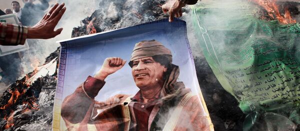 Un habitant de Benghazi (Libye) brûlant un portrait de Mouammar Kadhafi - Sputnik Afrique