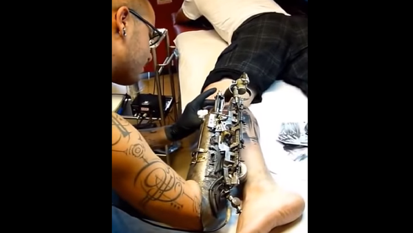 un tatoueur qui réalise son métier avec un bras biomécanique - Sputnik Afrique