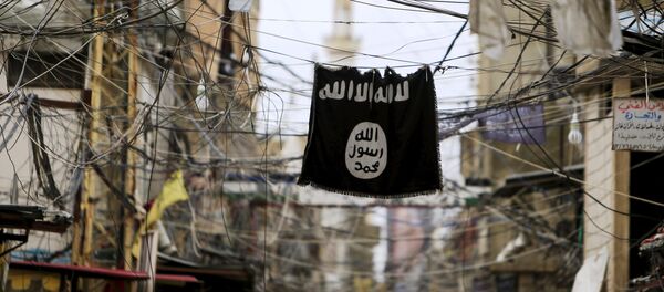 An Islamic State flag hangs amid electric wires over a street. - Sputnik Afrique