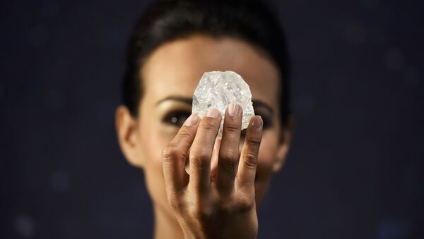 Le mannequin britannique montre le diamant Lesedi La Rona de 1.109 carats , le plus gros diamant brut  découvert dans plus de 100 ans lors de la présentation à la maison de vente aux enchères Sotheby's à Londres - Sputnik Afrique