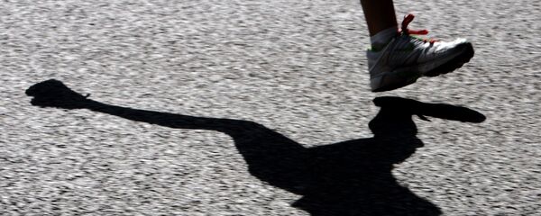A runner's shadow is cast onto the road as she enters the last five miles of the challenging route, 22 April 2007. - Sputnik Afrique