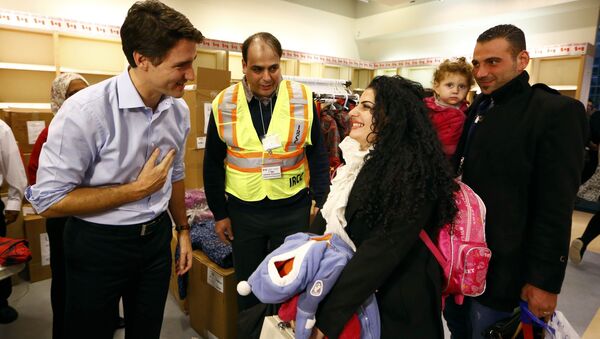 Syrian refugees are greeted by Canada's Prime Minister Justin Trudeau (L) on their arrival from Beirut at the Toronto Pearson International Airport in Mississauga, Ontario, Canada December 11, 2015 - Sputnik Afrique