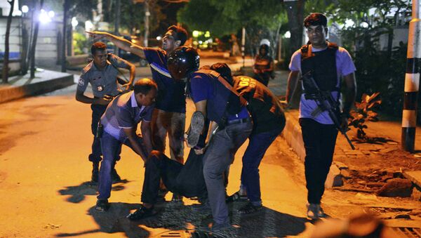 People help an unidentified injured person after a group of gunmen attacked a restaurant popular with foreigners in a diplomatic zone of the Bangladeshi capital Dhaka, Bangladesh, Friday, July 1, 2016. - Sputnik Afrique