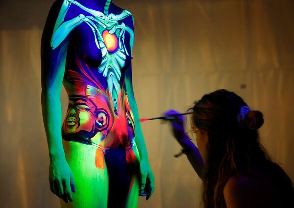 Un artiste utilise de la peinture ultraviolette lors du World Bodypainting Festival 2016. 1er juillet 2016. - Sputnik Afrique
