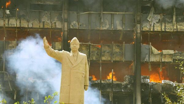 Une statue de Saddam Hussein devant le siège du comité olympique irakien en avril 2003. - Sputnik Afrique