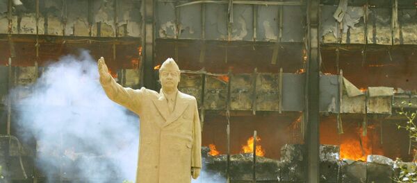 Une statue de Saddam Hussein devant le siège du comité olympique irakien en avril 2003. - Sputnik Afrique