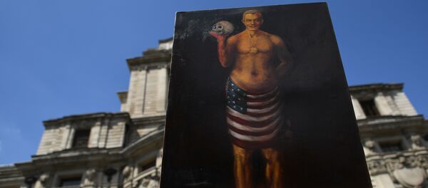 Satirical artist Kaya Mar poses with an artwork depicting former British Prime Minister Tony Blair draped in a US flag during a protest near to the venue of the publication of the Iraq Inquiry report in London on July 6, 2016. - Sputnik Afrique