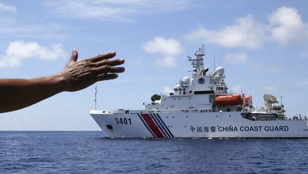 In this photo taken March 29, 2014, Philippines navy personnel motions towards a Chinese Coast Guard to make way as they block them from entering Second Thomas Shoal in the South China Sea. - Sputnik Afrique