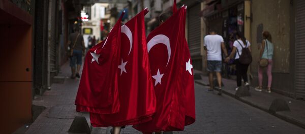 Two men carry Turkish flags for selling as they walk along a street in downtown Istanbul, Sunday, July 17, 2016. - Sputnik Afrique