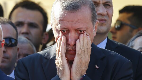 Le président turc Recep Tayyip Erdogan essuie ses larmes lors des funérailles de Mustafa Cambaz, Erol et Abdullah Olcak, tués vendredi alors qu'ils protestaient contre la tentative de coup d'Etat contre le gouvernement turc, à Istanbul, le 17 juillet, 2016. - Sputnik Afrique