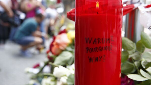 A candle with the words 'Why?' written upon it is placed next to flowers near the Olympia shopping mall, where yesterday's shooting rampage started, in Munich, Germany July 23, 2016. - Sputnik Afrique