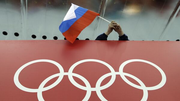 Un supporter tenant le drapeau russe lors des Jeux olympiques - Sputnik Afrique