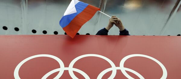 Un supporter tenant le drapeau russe lors des Jeux olympiques - Sputnik Afrique