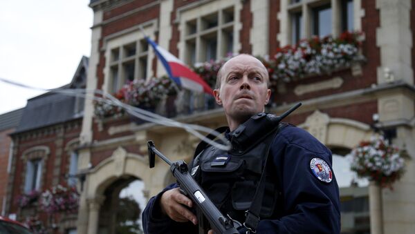 A policeman secures a position in front of the city hall after two assailants had taken five people hostage in the church at Saint-Etienne-du -Rouvray near Rouen in Normandy, France, July 26, 2016 - Sputnik Afrique