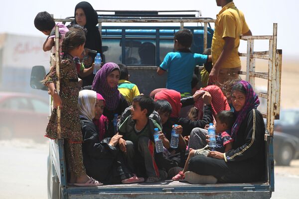 Des femmes et des enfants irakiens fuient les villes d'Al-Shirqat et d'Qayyarah, où se poursuivent les combats entre les forces gouvernementales et les terroristes du groupe extrémiste Etat Islamique. - Sputnik Afrique