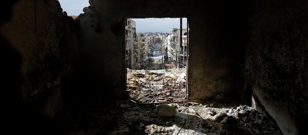 Damaged buildings are seen through a door at al-Ezaa frontline in Aleppo, March 2, 2015. - Sputnik Afrique