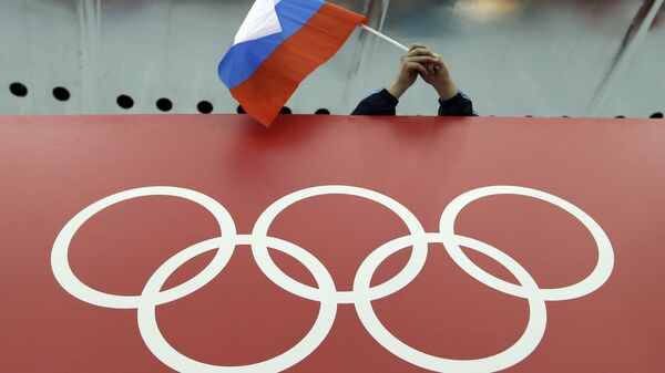 Un supporter tenant le drapeau russe lors des Jeux olympiques - Sputnik Afrique