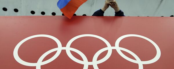 Un supporter tenant le drapeau russe lors des Jeux olympiques - Sputnik Afrique