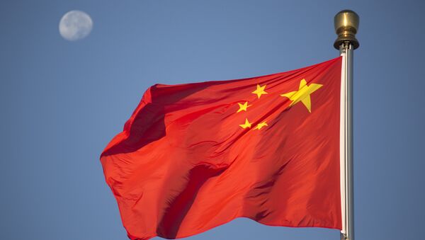 he moon sets above a Chinese flag flying over Tiananmen Square after a flag raising ceremony on National Day, the 66th anniversary of the founding of the People's Republic of China, in Beijing, Thursday, Oct. 1, 2015 - Sputnik Afrique