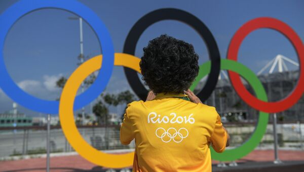A man at the Olympic rings at the Olympic Park in Rio de Janeiro - Sputnik Afrique
