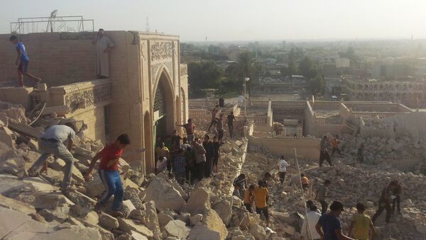 People walk on the rubble of the destroyed Mosque of The Prophet Younis, or Jonah, in Mosul, 225 miles (360 kilometers) northwest of Baghdad, Iraq (File) - Sputnik Afrique