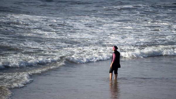 A Moroccan woman wearing a burkini, a full-body swimsuit designed for Muslim women, enters the sea at Oued Charrat beach, near the capital Rabat - Sputnik Afrique