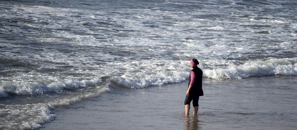 A Moroccan woman wearing a burkini, a full-body swimsuit designed for Muslim women, enters the sea at Oued Charrat beach, near the capital Rabat - Sputnik Afrique