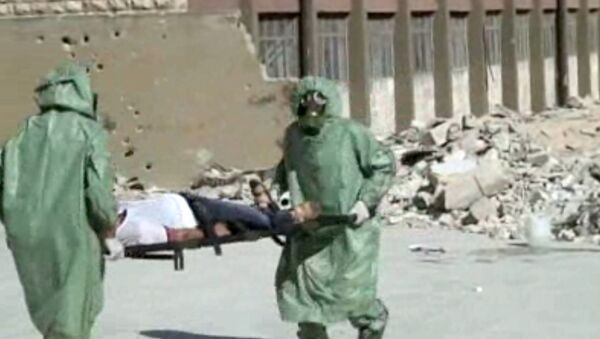 FILE - This image made from an AP video posted on Wednesday, Sept. 18, 2013 shows shows Syrians in protective suits and gas masks conducting a drill on how to treat casualties of a chemical weapons attack in Aleppo, Syria. The Islamic State group is aggressively pursuing development of chemical weapons, setting up a branch dedicated to research and experiments with the help of scientists from Iraq, Syria and elsewhere in the region, according to Iraqi and U.S. intelligence officials. (AP Photo via AP video, File) - Sputnik Afrique