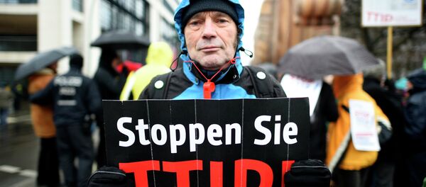 A protester holds up a sign, reading: Stop TTIP! (Transatlantic Trade and Investment Partnership) A protester holds up a sign, reading: Stop TTIP! (Transatlantic Trade and Investment Partnership) - Sputnik Afrique