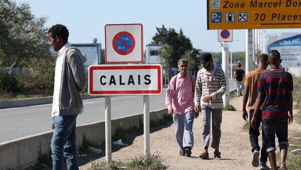 Migrants pass by a road sign as they leave the northern area of the camp called the Jungle in Calais, France, September 7, 2016. - Sputnik Afrique