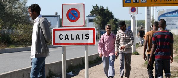 Migrants pass by a road sign as they leave the northern area of the camp called the Jungle in Calais, France, September 7, 2016. - Sputnik Afrique