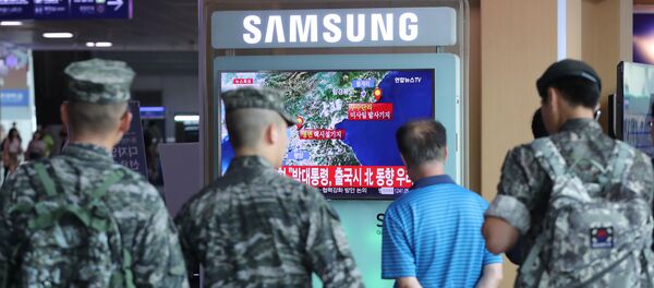 South Korean soldiers and passenger watch a TV broadcasting a news report on Seismic activity produced by a suspected North Korean nuclear test, at a railway station in Seoul, South Korea, September 9, 2016. - Sputnik Afrique