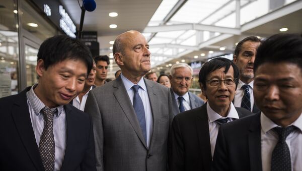French right-wing Les Republicains (LR) party's mayor of Bordeaux and candidate for the LR party primary Alain Juppe (2-L) and French senator and former Prime Minister Jean-Pierre Raffarin (C) visit a store in the Chinese community in Aubervilliers, near to Paris, on September 8, 2016. - Sputnik Afrique