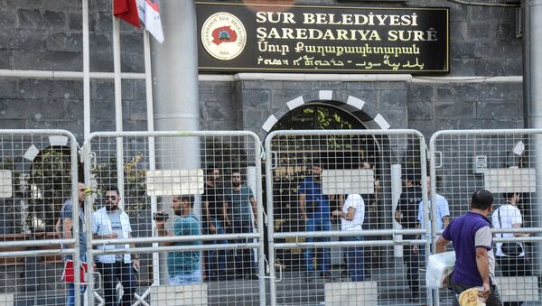 People walk next to barriers in front of the Sur municipality building during an police operation on September 11, 2016, in Diyarbakir. - Sputnik Afrique