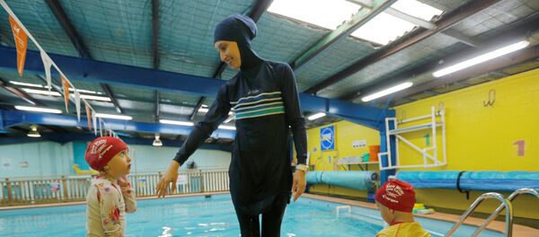 REFILE - CORRECTING TYPOAustralian muslim swimming instructor Fadila Chafic wears her full-length 'burkini' swimsuit during a swimming lesson with her children Taaleen (L) and Ibrahim at swimming pool in Sydney, August 23, 2016. - Sputnik Afrique
