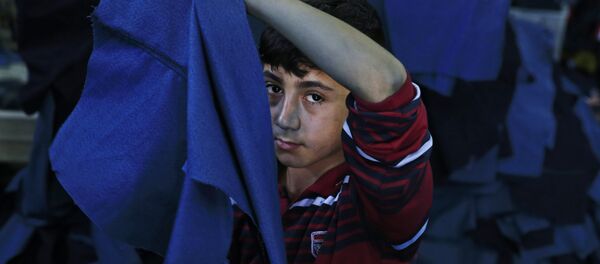 In this Thursday, June 2, 2016 photo, Mohammed, a Syrian refugee child works at a clothing workshop in Gaziantep, southeastern Turkey - Sputnik Afrique