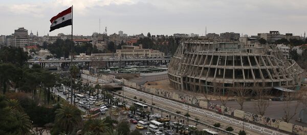 A Syrian national flag waves as vehicles move slowly in a traffic jam during rush hours on a road in Damascus , Syria (File) - Sputnik Afrique