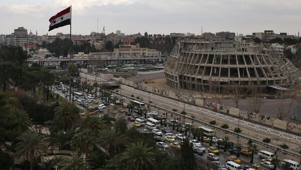 A Syrian national flag waves as vehicles move slowly in a traffic jam during rush hours on a road in Damascus , Syria (File) - Sputnik Afrique