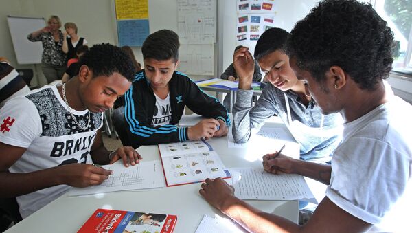 17-year old Benni Gergin (R) from Giessen is learning together with 20-year old refugee Abel Solomon from Eritrea at the Friedrich-Feld vocational school of commerce in Giessen, central Germany, on June 17, 2015. - Sputnik Afrique