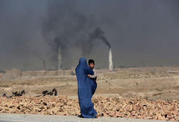 Афганская женщина с ребенком на руках в Кабуле - Sputnik Afrique