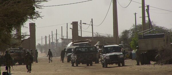Malian soldiers stand guard at a checkpoint at the entrance to Timbuktu, Mali, after unknown assailants attacked and withdrew from inside a UN police base in the city, February 5, 2016. - Sputnik Afrique