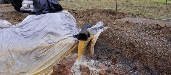 In this Aug. 12, 2015, file photo, an Environmental Protection Agency contractor works on the clean up in the aftermath of the blowout at the Gold King mine, overseeing water flowing from the mine into a series of sediment retention ponds, mitigating damage from the spill of toxic wastewater, outside Silverton, Colo. - Sputnik Afrique