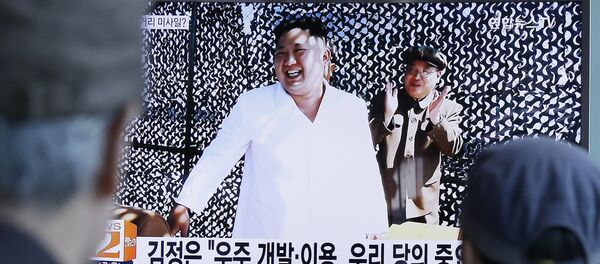 People watch a TV news program showing an image, published in North Korea's Rodong Sinmun newspaper, of North Korean leader Kim Jong Un at the country's Sohae Space Center, at Seoul Railway station in Seoul, South Korea, Tuesday, Sept. 20, 2016. - Sputnik Afrique