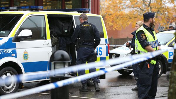 Police officers stand guard at a cordoned area after a masked man attacked people with a sword at a school in Trollhattan, western Sweden October 22, 2015 - Sputnik Afrique