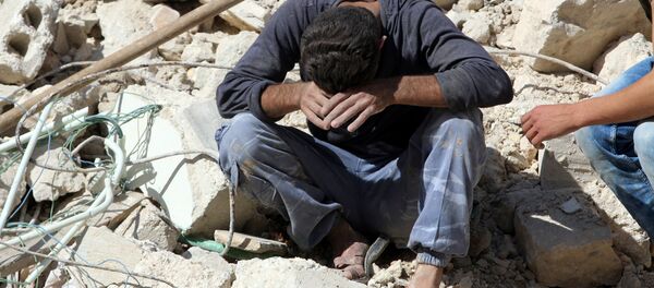 A man reacts on the rubble of damaged buildings after losing relatives to an airstrike in the besieged rebel-held al-Qaterji neighbourhood of Aleppo, Syria October 11, 2016. - Sputnik Afrique