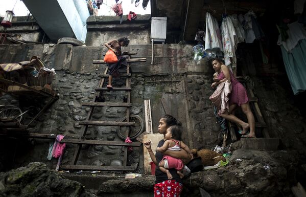 Женщина поднимается по лестнице, чтобы укрыться от тайфуна - Sputnik Afrique
