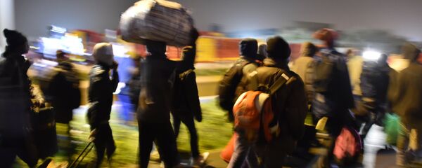 Migrants queue for transportation by bus to reception centres across France, from the Jungle migrant camp in Calais, northern France, on October 24, 2016. - Sputnik Afrique