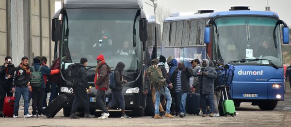Migrants carrying their luggages embark buses to leave the Jungle migrant camp in Calais, on October 24, 2016. - Sputnik Afrique