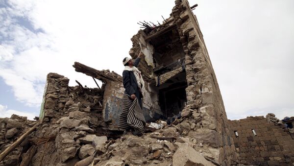 A man points up at a house that was damaged during an airstrike carried out by the Saudi-led coalition in Faj Attan village, Sanaa, Yemen May 7, 2015. - Sputnik Afrique